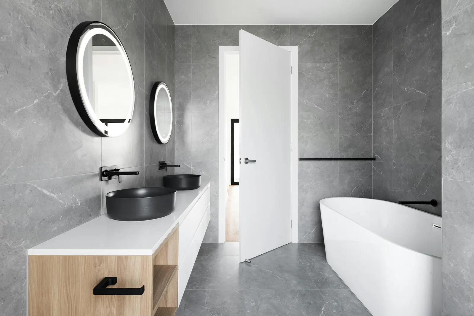 Grey stone bathroom with a freestanding tub and wall-mounted basin